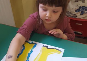 Dziewczynka maluje kalosze.